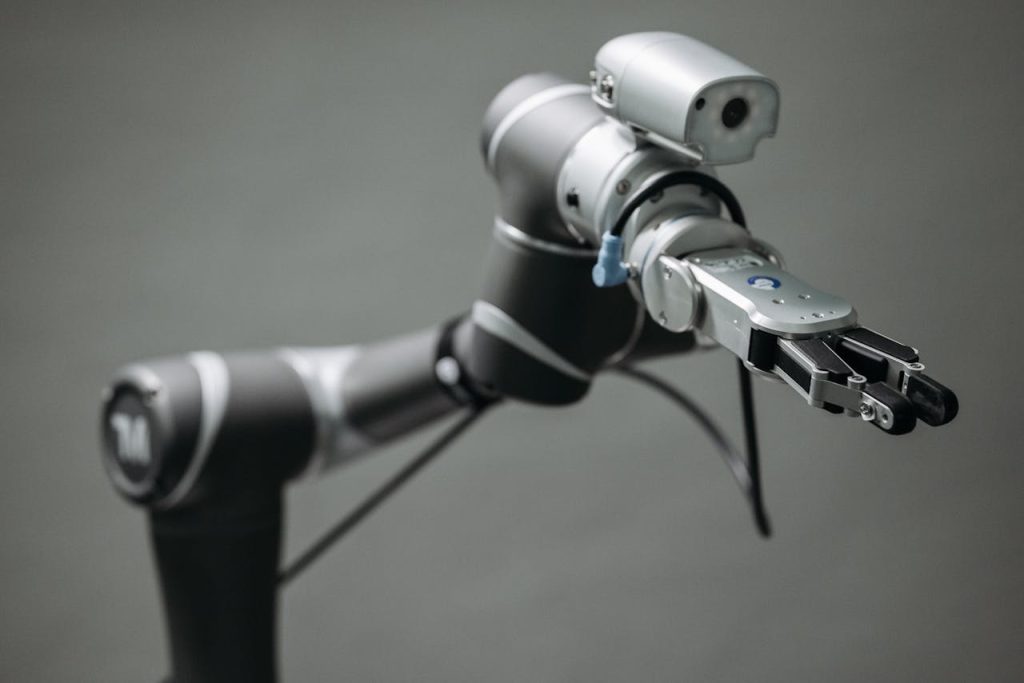 a-video-camera-on-a-stand-8438976 Close-up view of a robotic arm equipped with a video camera, showcasing modern technology.