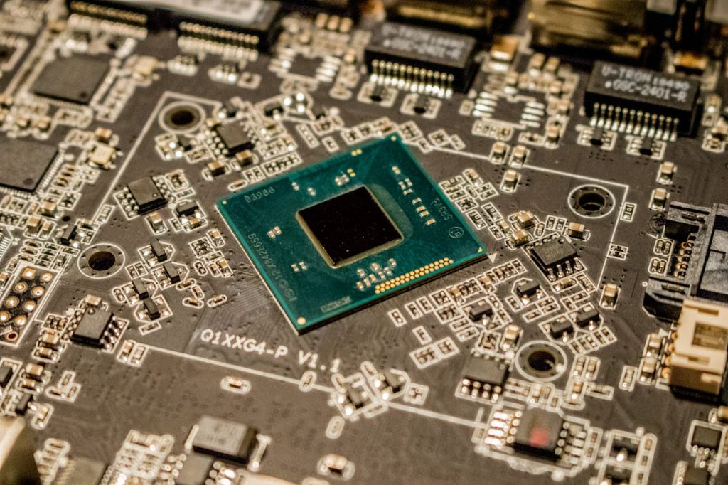 green-and-black-circuit-board-3665442 Detailed view of a microchip on a printed circuit board, showcasing electronic components.